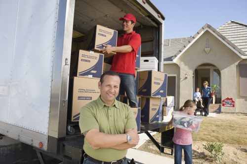 Packed moving boxes and household items for a van removal