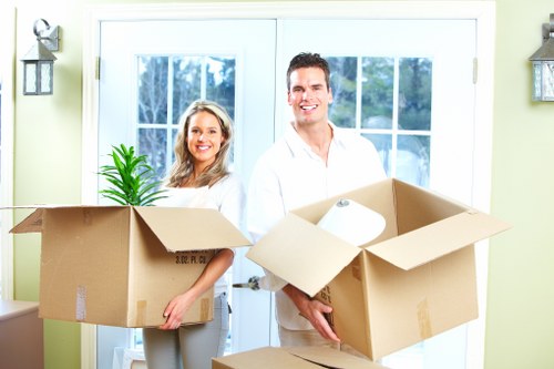 Professional movers carrying items through a West Hampstead property entrance