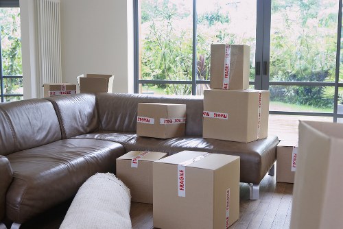 Moving team handling boxes and furniture in a local London property